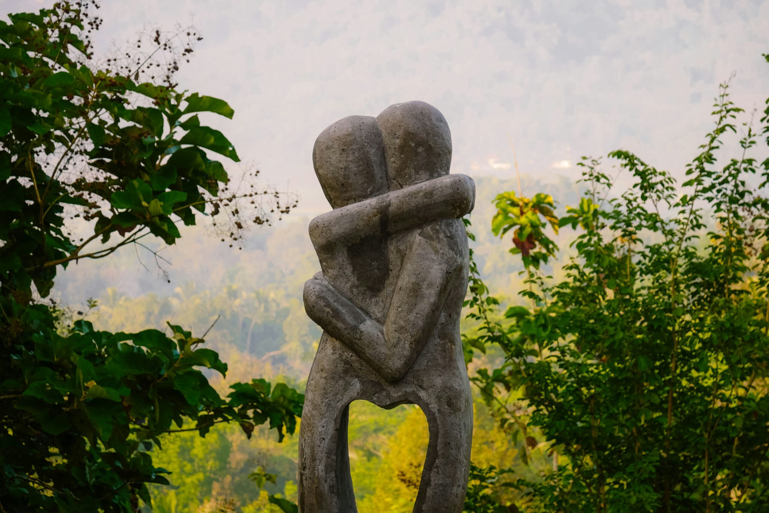 concrete statue of two figures hugging
